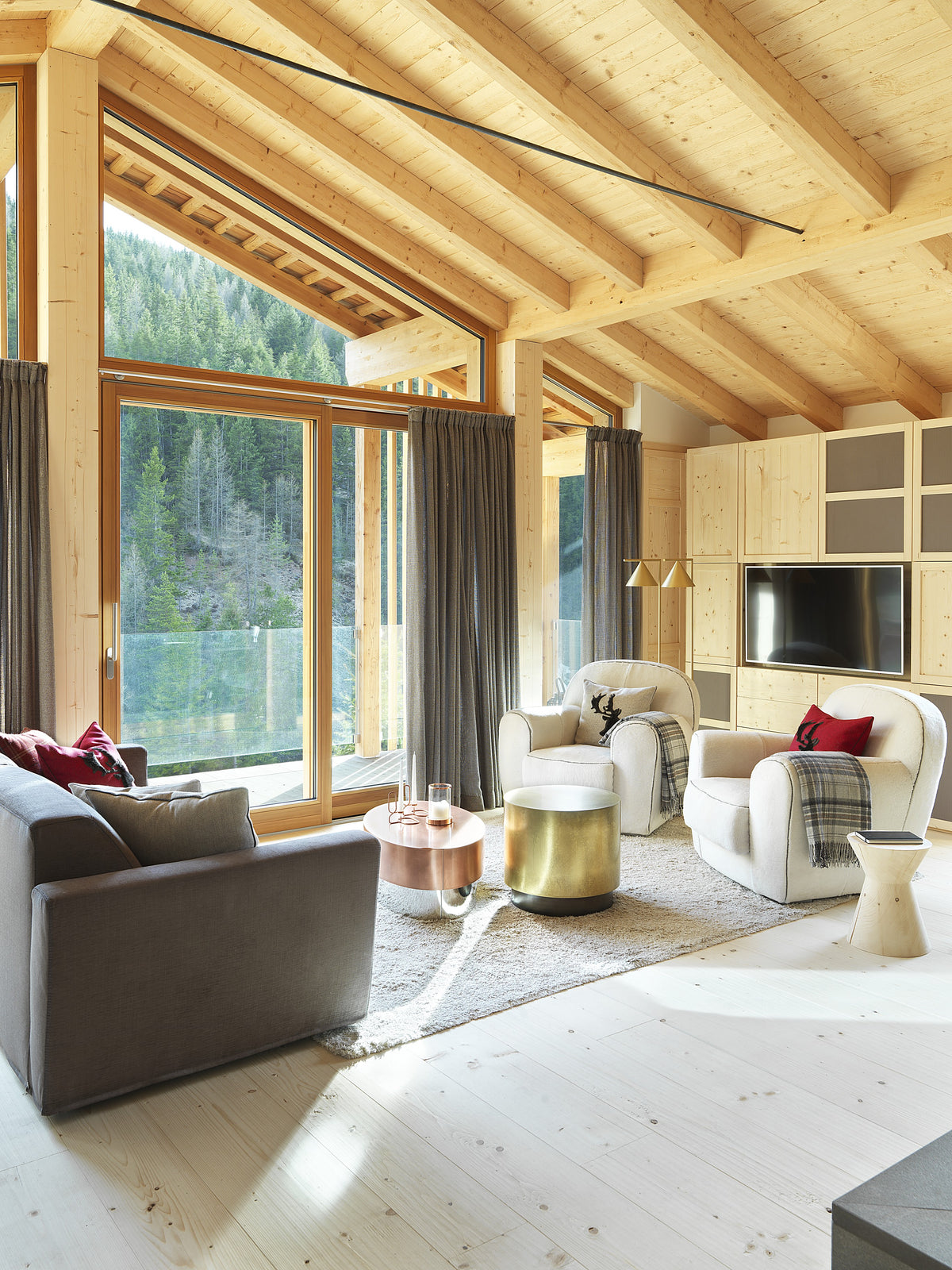 Zona relax con poltrone chiare e tavolini in metallo, luce naturale diffusa dalle ampie aperture