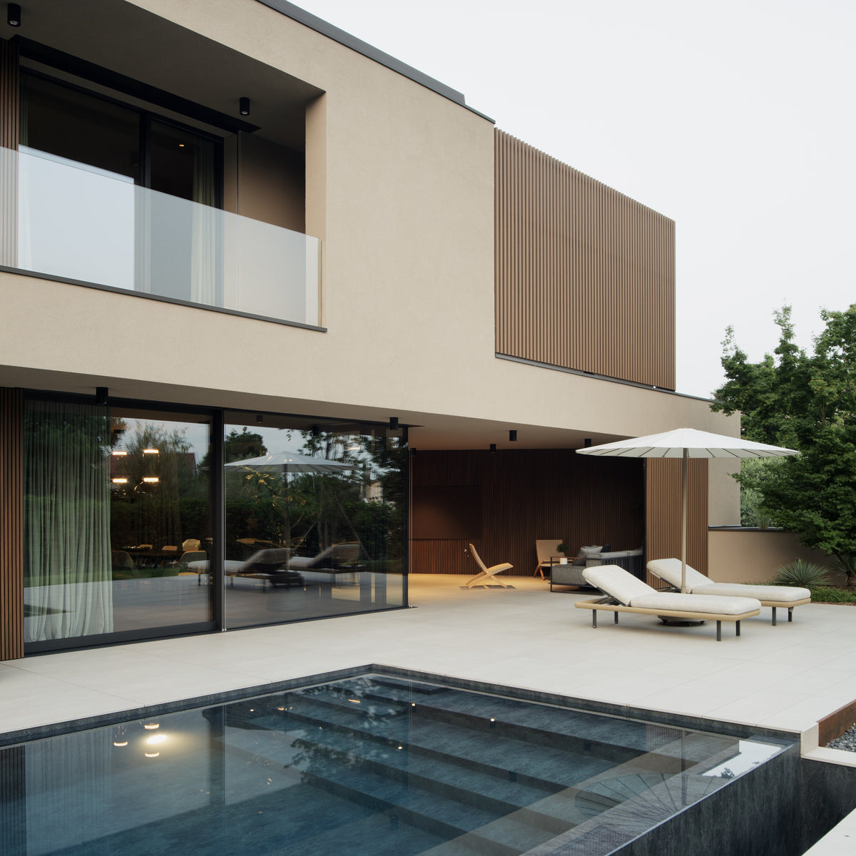 Villa contemporanea con piscina rettangolare, patio e facciata in intonaco e legno