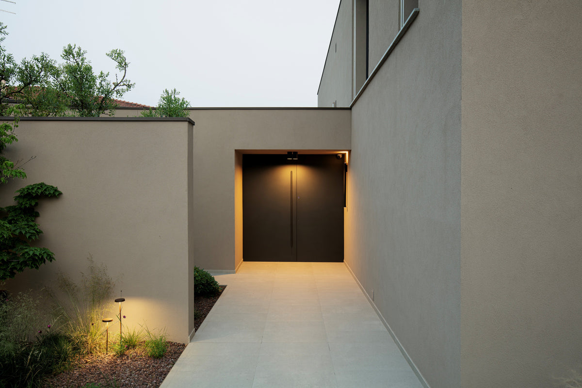 Ingresso della villa con percorso esterno essenziale e illuminazione integrata