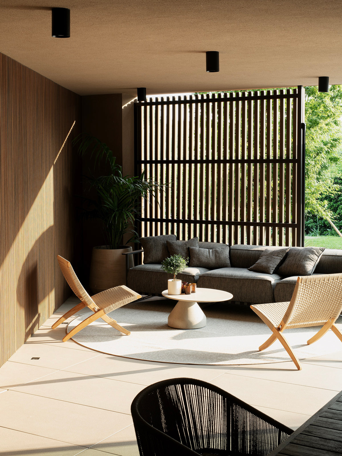 Patio outdoor coperto con zona lounge e frangisole in legno su misura