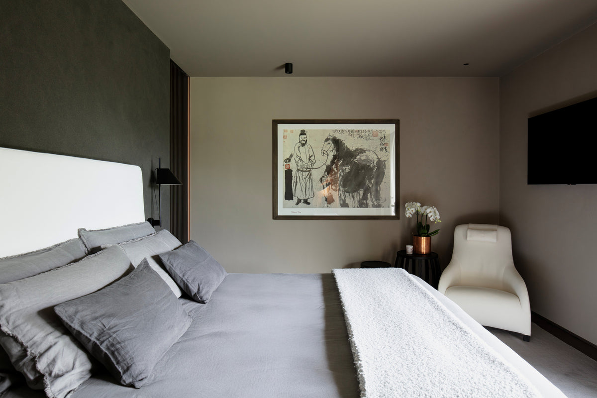 Camera padronale con letto tessile e angolo relax con poltrona