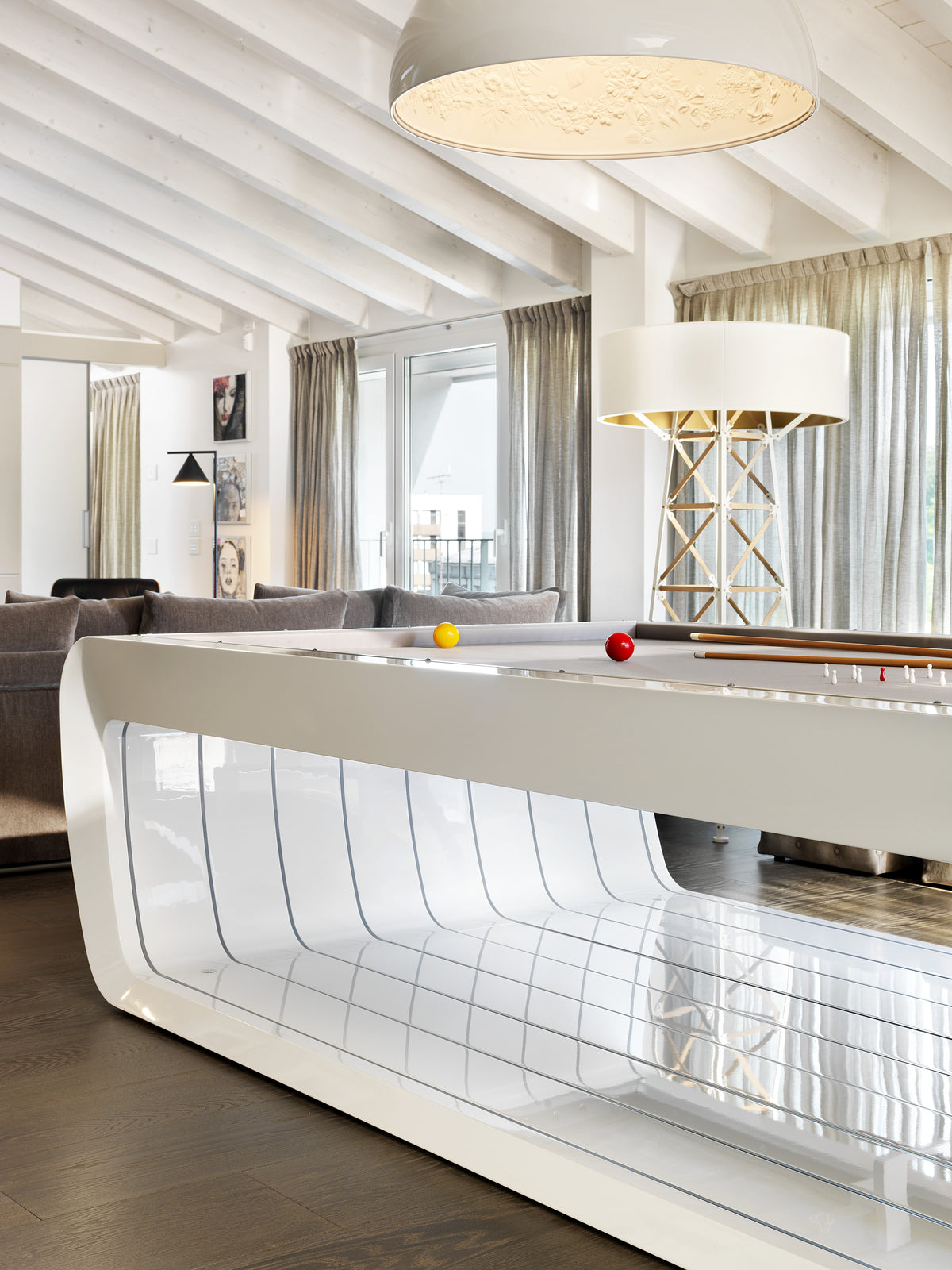 Tavolo da biliardo nell’open space con soffitto bianco con travi a vista e luce naturale