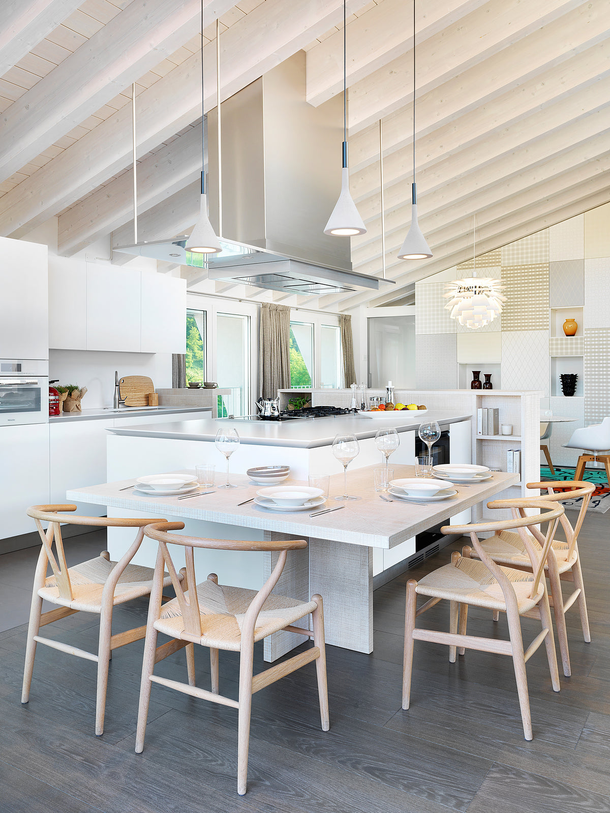 Cucina contemporanea con isola e cappa sospesa, tavolo snack e arredo su misura