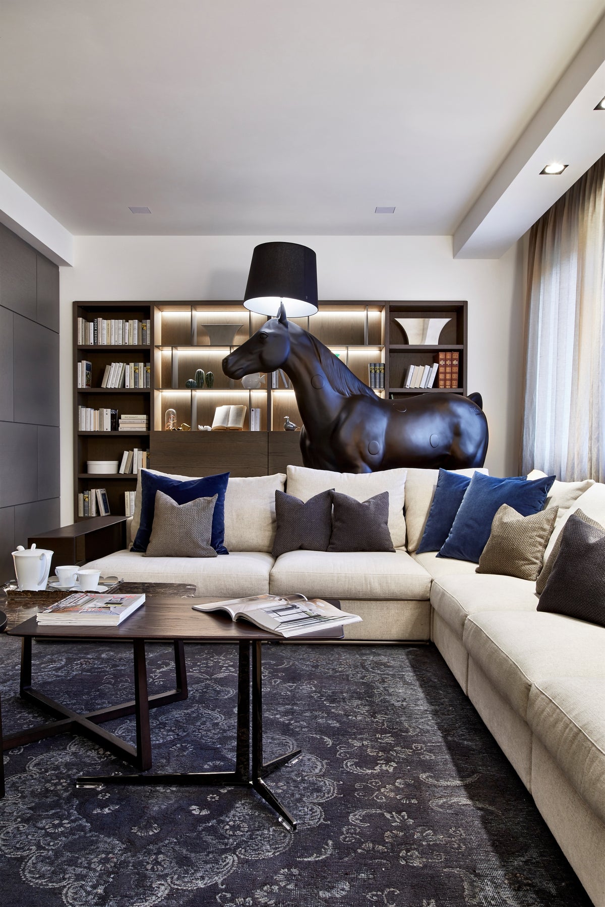 Dettaglio del living con divano modulare, libreria su misura e lampada decorativa