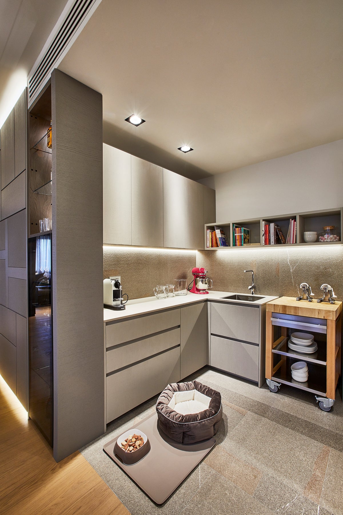 Angolo di servizio della cucina con basi contenitive, mensole illuminate e soluzioni funzionali su misura
