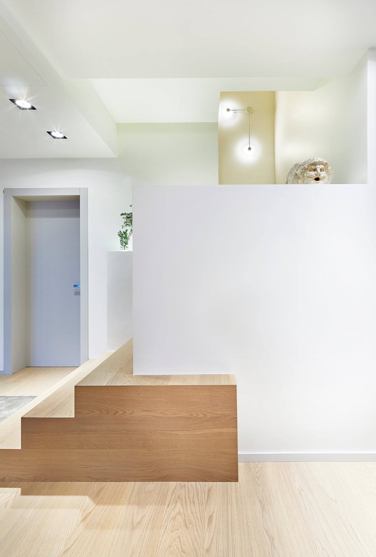 Scala moderna di design con tre scalini in legno e illuminazione decorativa