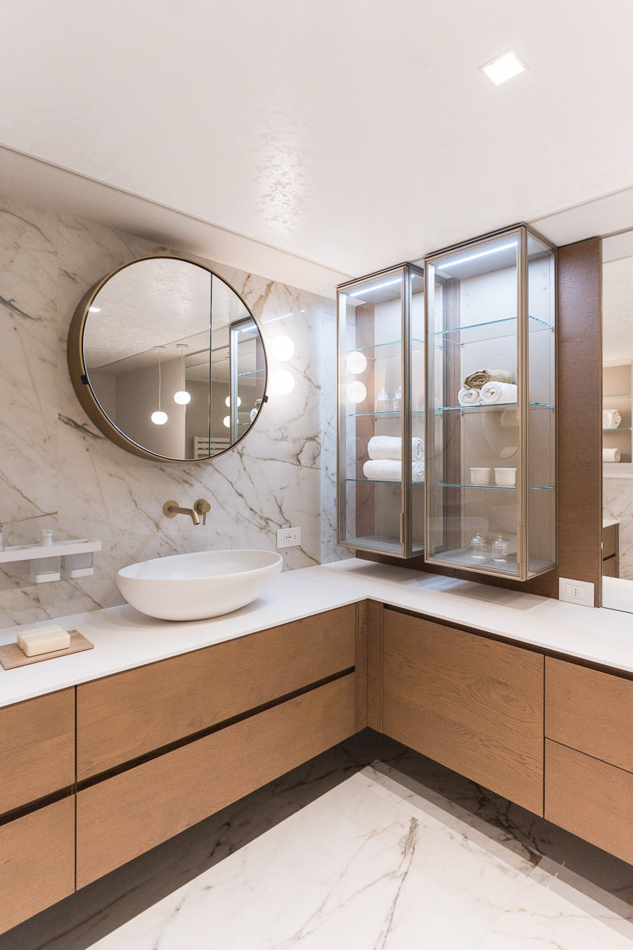 Bagno en suite in marmo chiaro con doppio lavabo e finiture eleganti