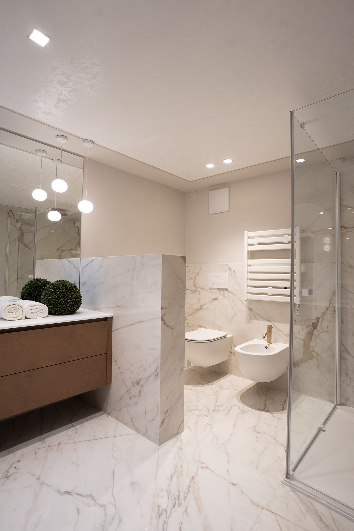 Bagno contemporaneo con sanitari sospesi e finiture neutre dallo stile classico