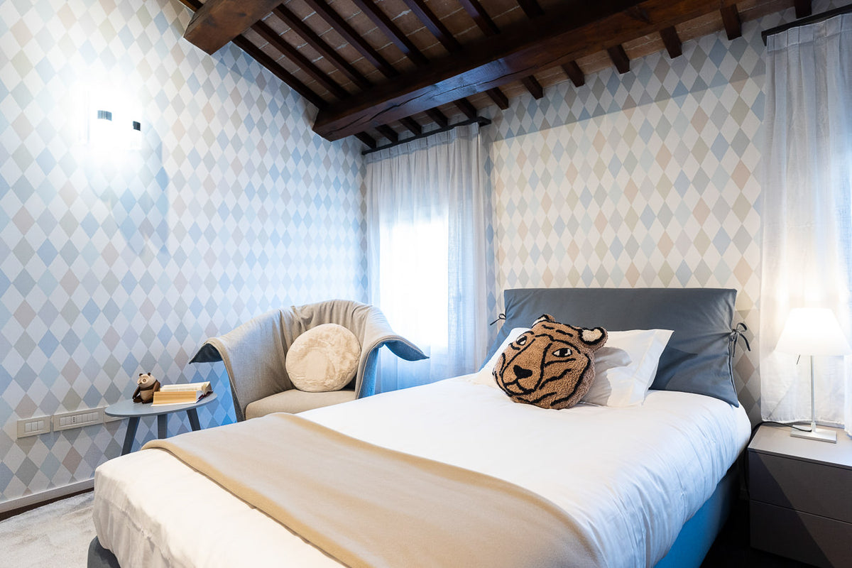 Cameretta con carta da parati decorativa a rombi e arredo su misura