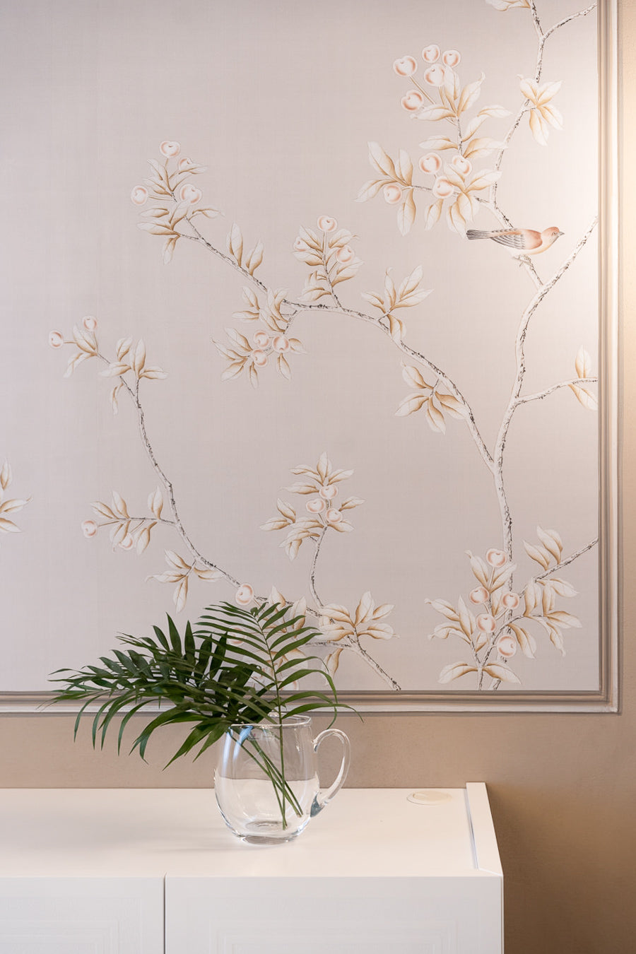 Dettaglio della boiserie decorativa con motivi floreali e vasi in vetro