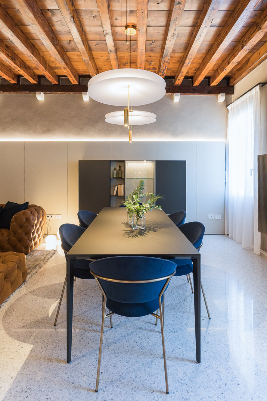Dettaglio del living con tavolo da pranzo e parete illuminata