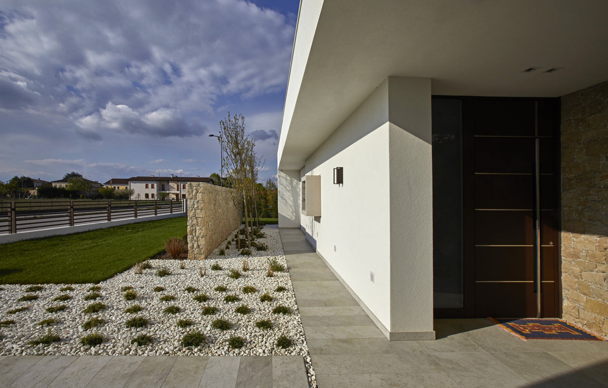 Ingresso della villa contemporanea con facciata minimale e percorso esterno geometrico