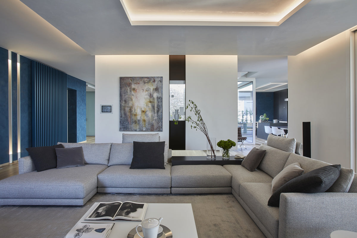 Soggiorno con boiserie blu e divano modulare, progetto di interior design su misura