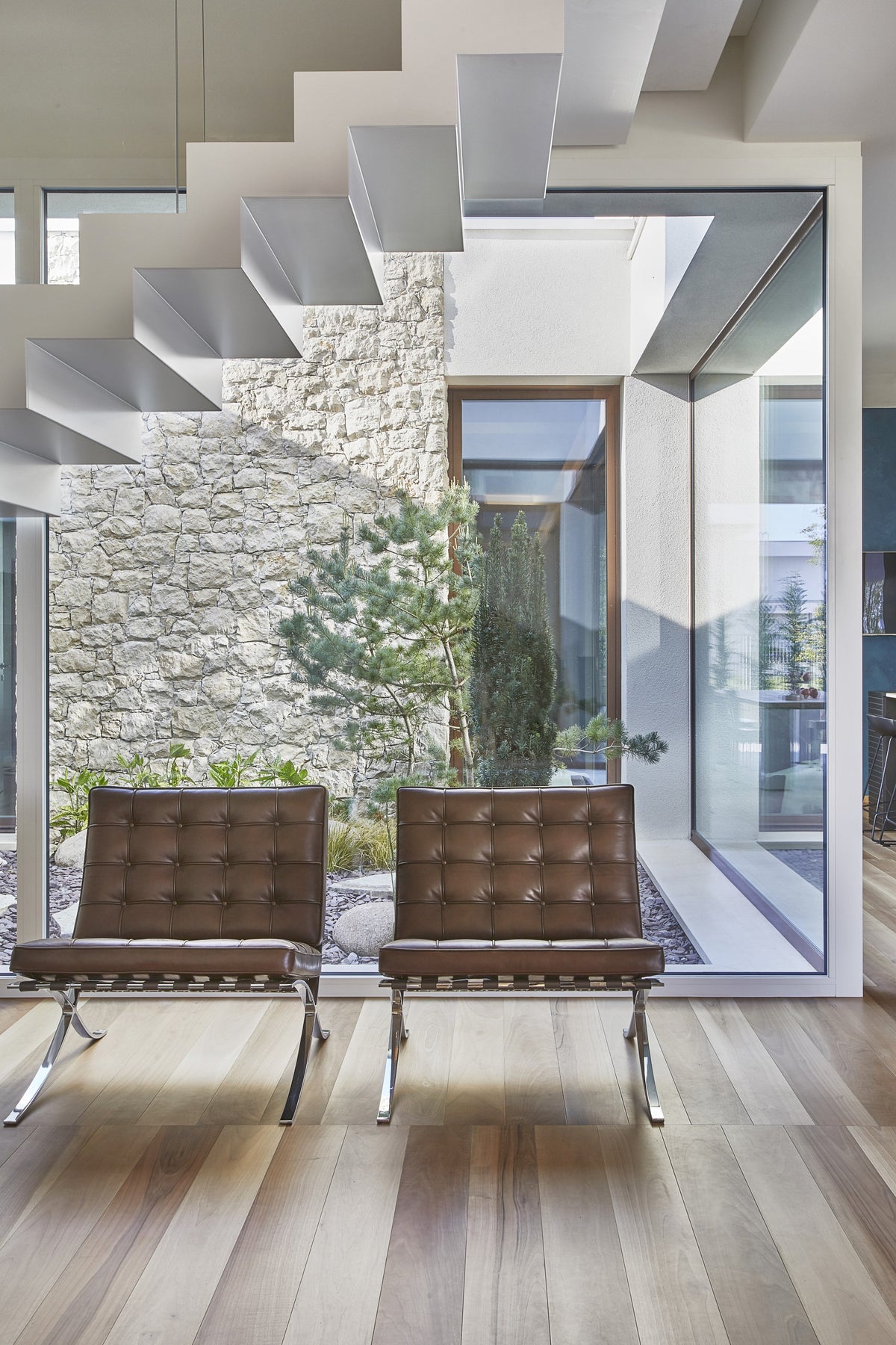 Sedute di design accanto alla scala sospesa con vista sul giardino interno