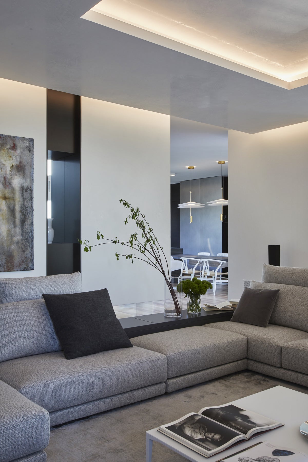 Dettaglio del living con divano, nicchia decorativa e continuità materica