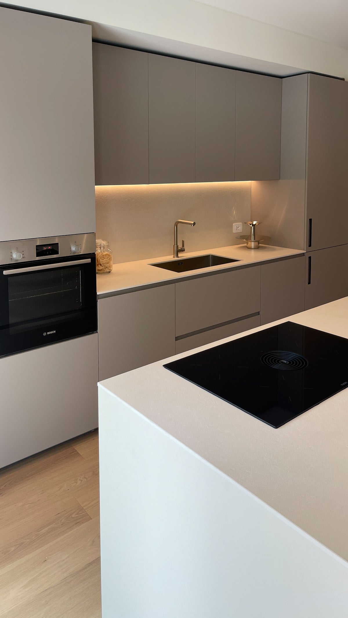 Cucina contemporanea su misura con isola operativa, piano cottura e parete attrezzata a tutta altezza