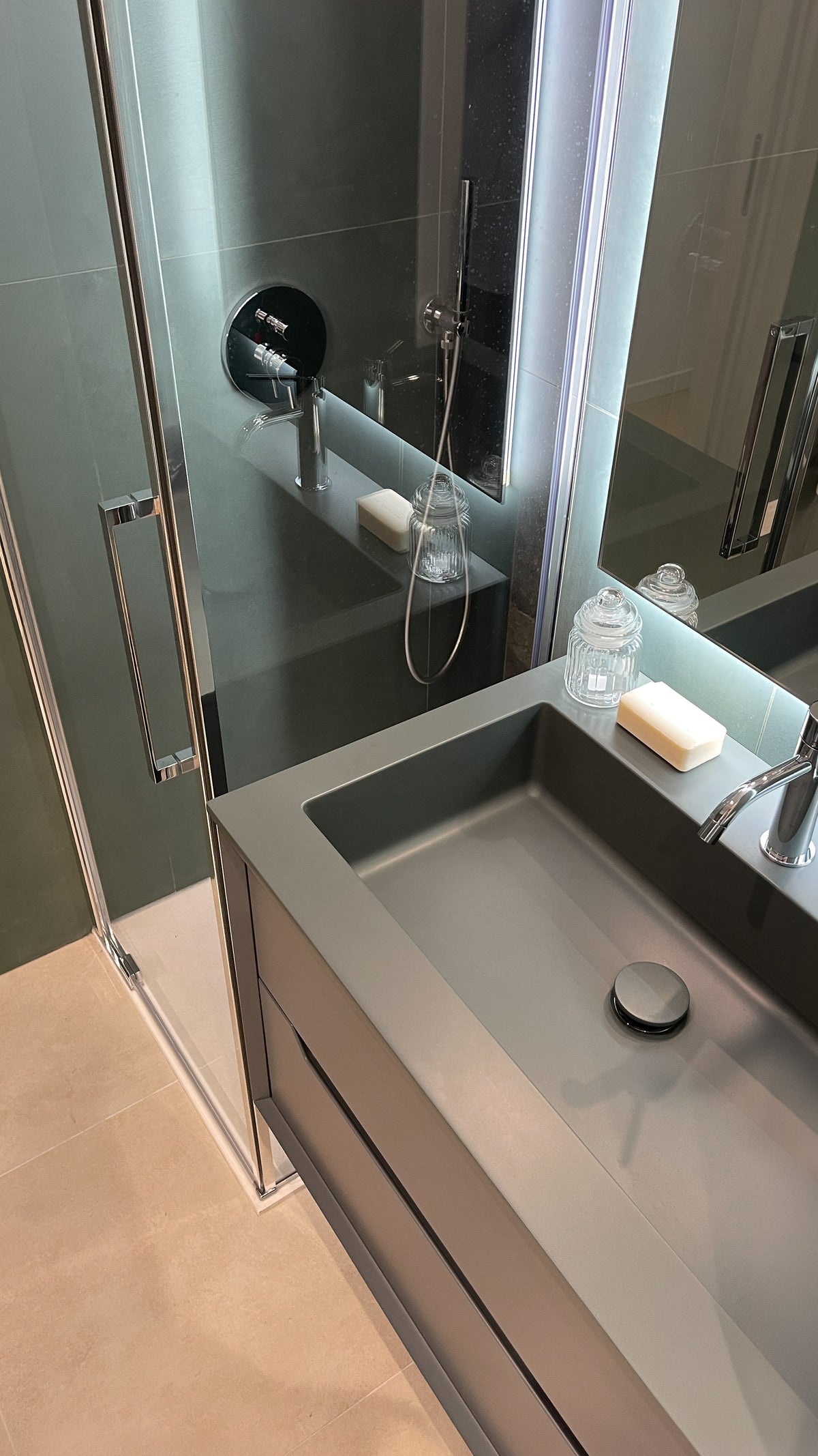 Dettaglio del mobile bagno sospeso con lavabo integrato e specchio retroilluminato