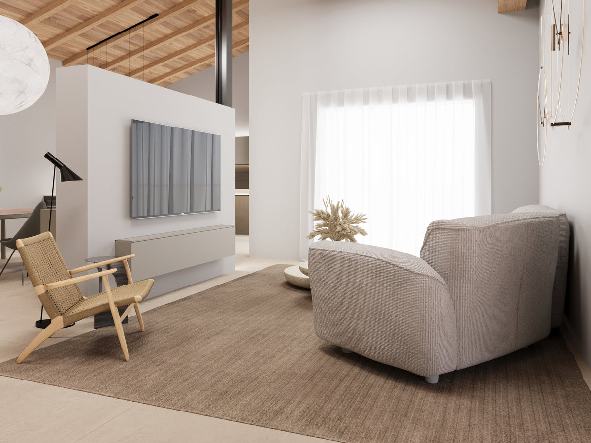 Render di living contemporaneo con parete TV centrale in quinta divisoria con madia incassata, tappeto neutro, poltrona intrecciata e divano dalle forme morbide