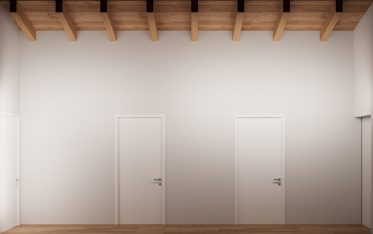 Prospetto del corridoio zona notte con soffitto alto, porte allineate e travi in legno a vista