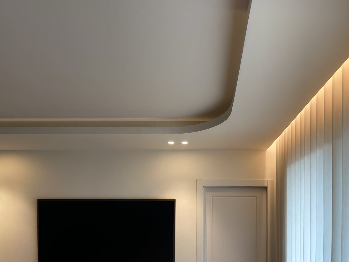 Dettaglio del controsoffitto curvo con illuminazione perimetrale integrata nella camera padronale