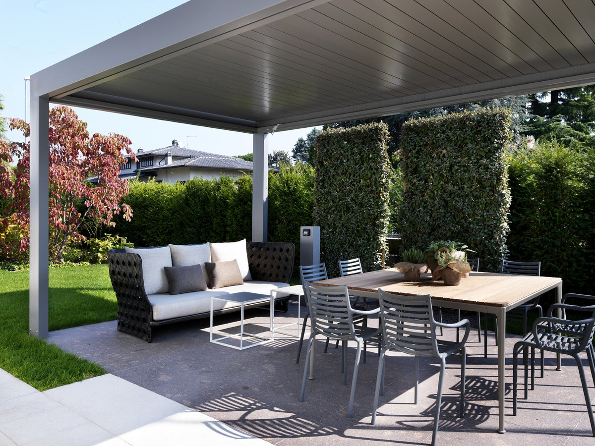 Zona pranzo outdoor coperta con tavolo quadrato e divano intrecciato moderno