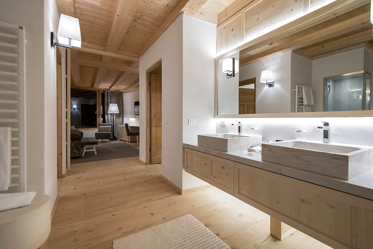 Bagno dello chalet con bancone e doppio lavabo, specchio retroilluminato e passaggio verso la zona notte