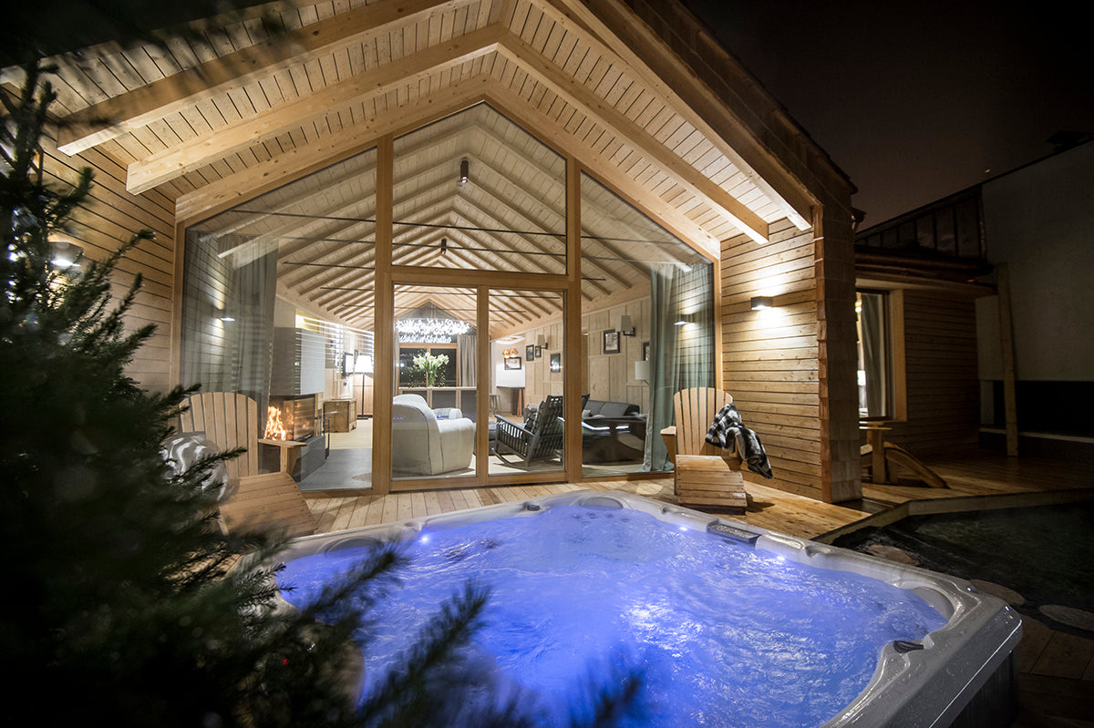 Vista notturno dello chalet con area relax e vasca idromassaggio esterna, nella nuova suite privata in Alta Badia