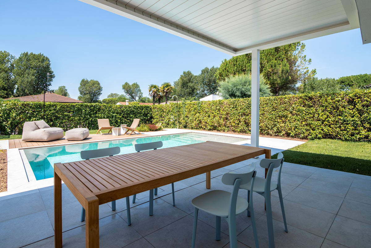 Zona pranzo outdoor sotto il portico affacciato sulla piscina e sul giardino