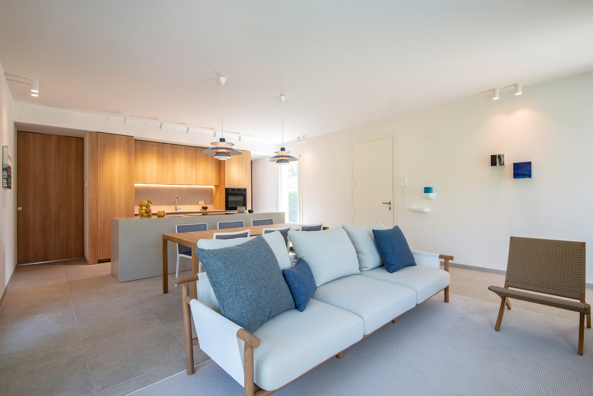 Zona giorno open space della casa ristrutturata ad Albarella con living, pranzo e cucina su misura