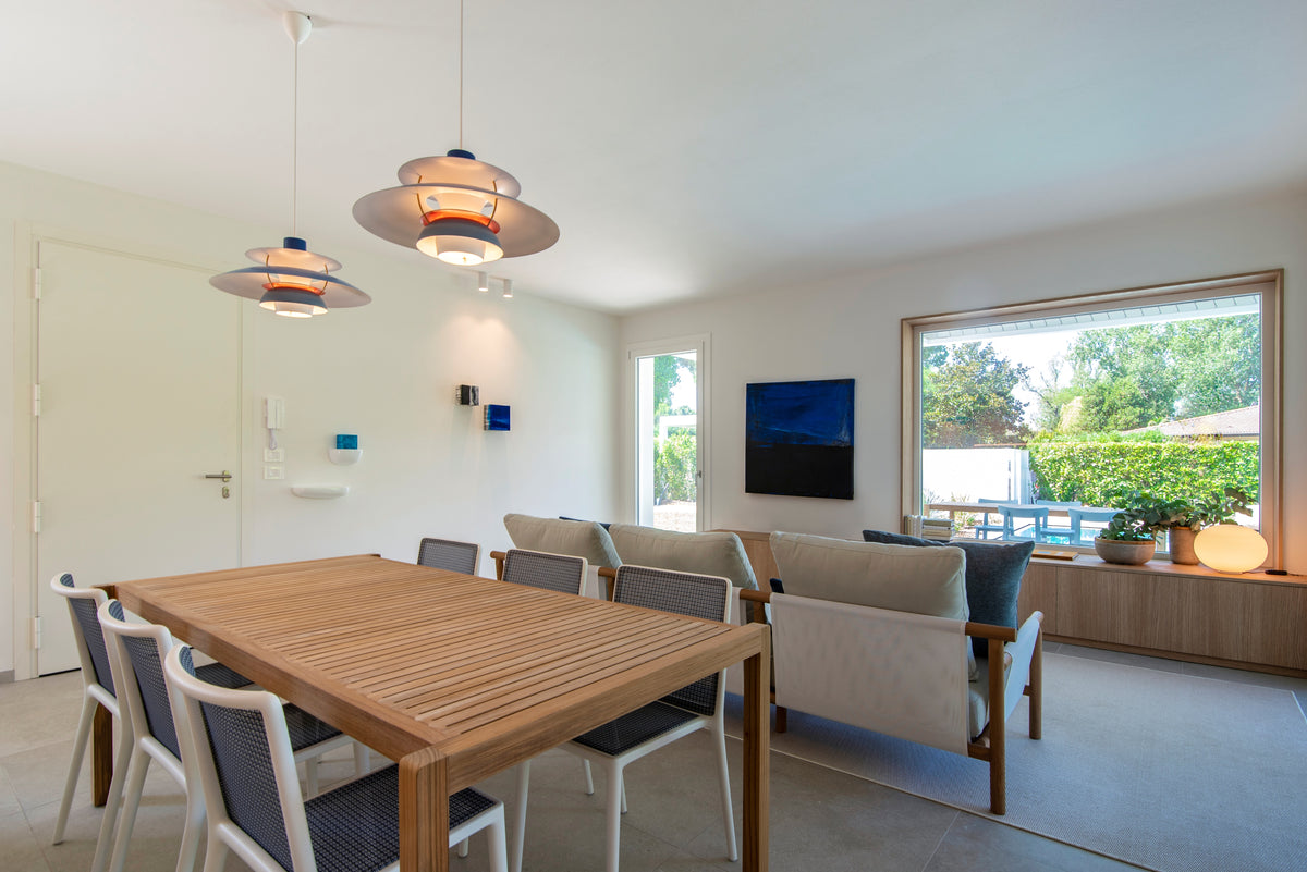 Tavolo da pranzo e living inseriti in un ambiente aperto e luminoso con vista sul verde