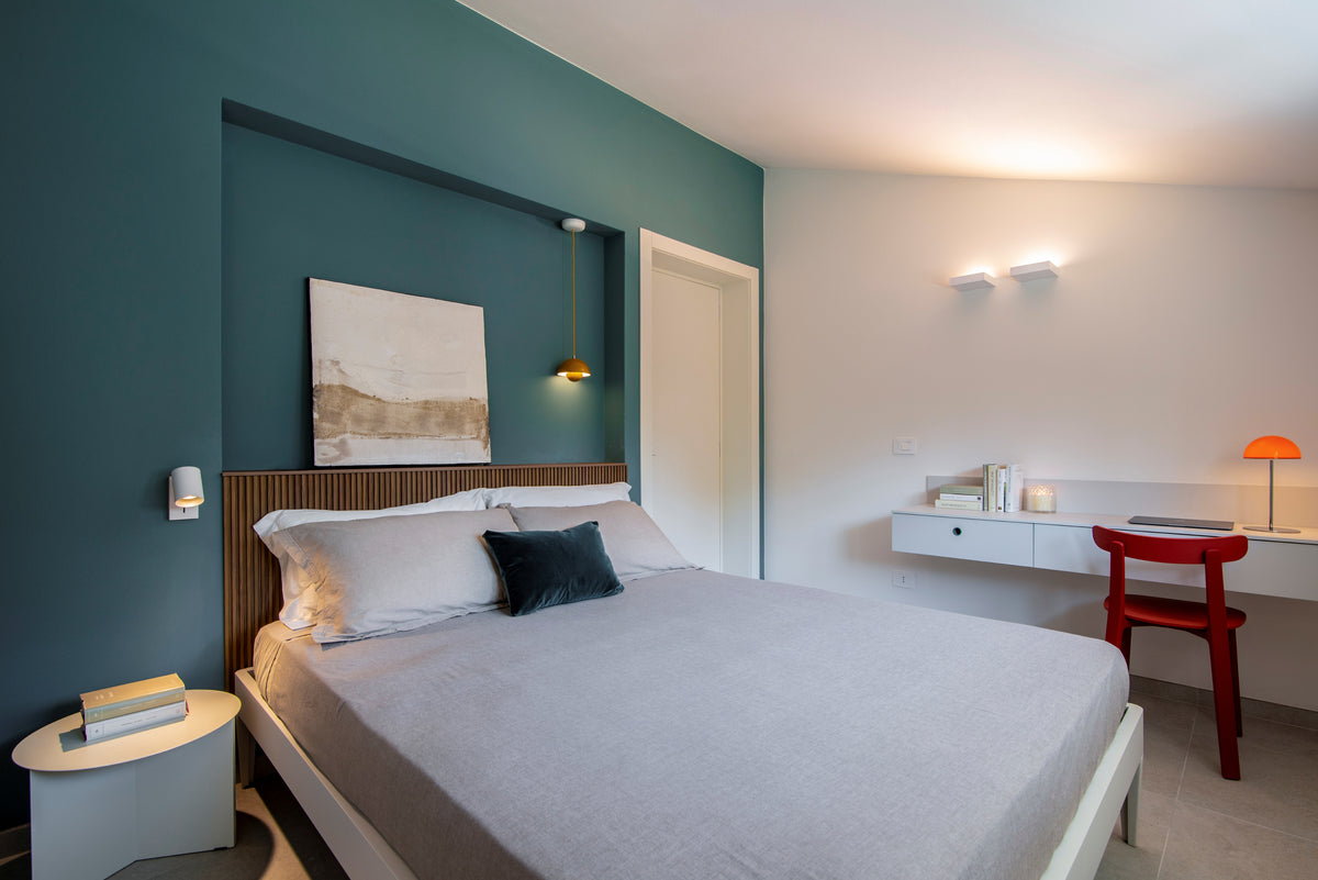 Seconda camera da letto con arredi su misura, boiserie retro letto in legno, parete blu petrolio e zona scrittoio