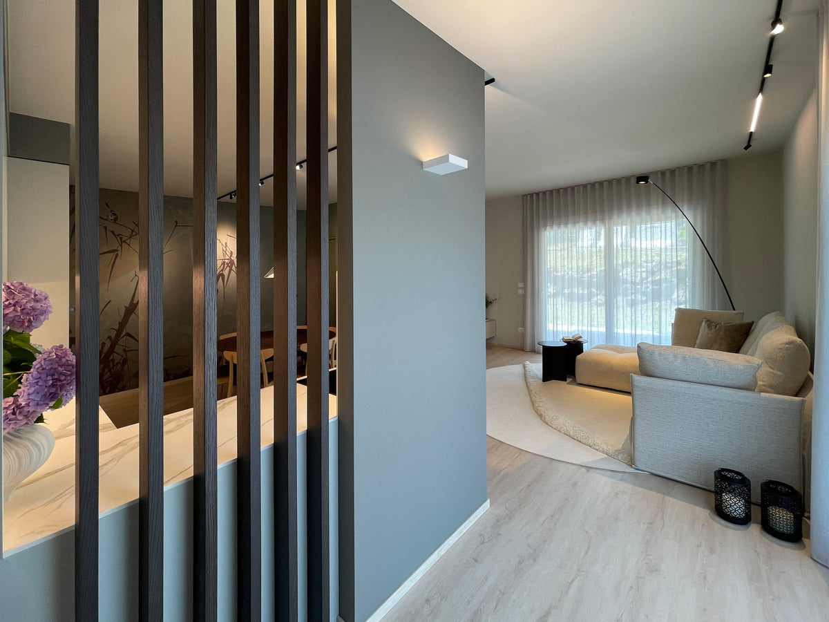Progettazione della zona giorno con listelli in legno divisori tra ingresso, cucina e living in un open space contemporaneo