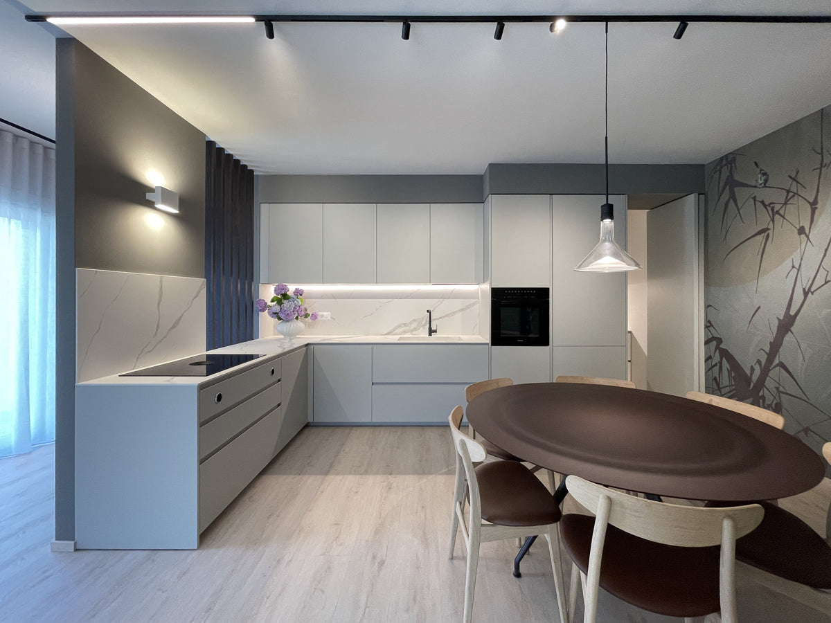 Cucina su misura con penisola, piano effetto marmo, illuminazione integrata e accesso alla zona di servizio nascosta