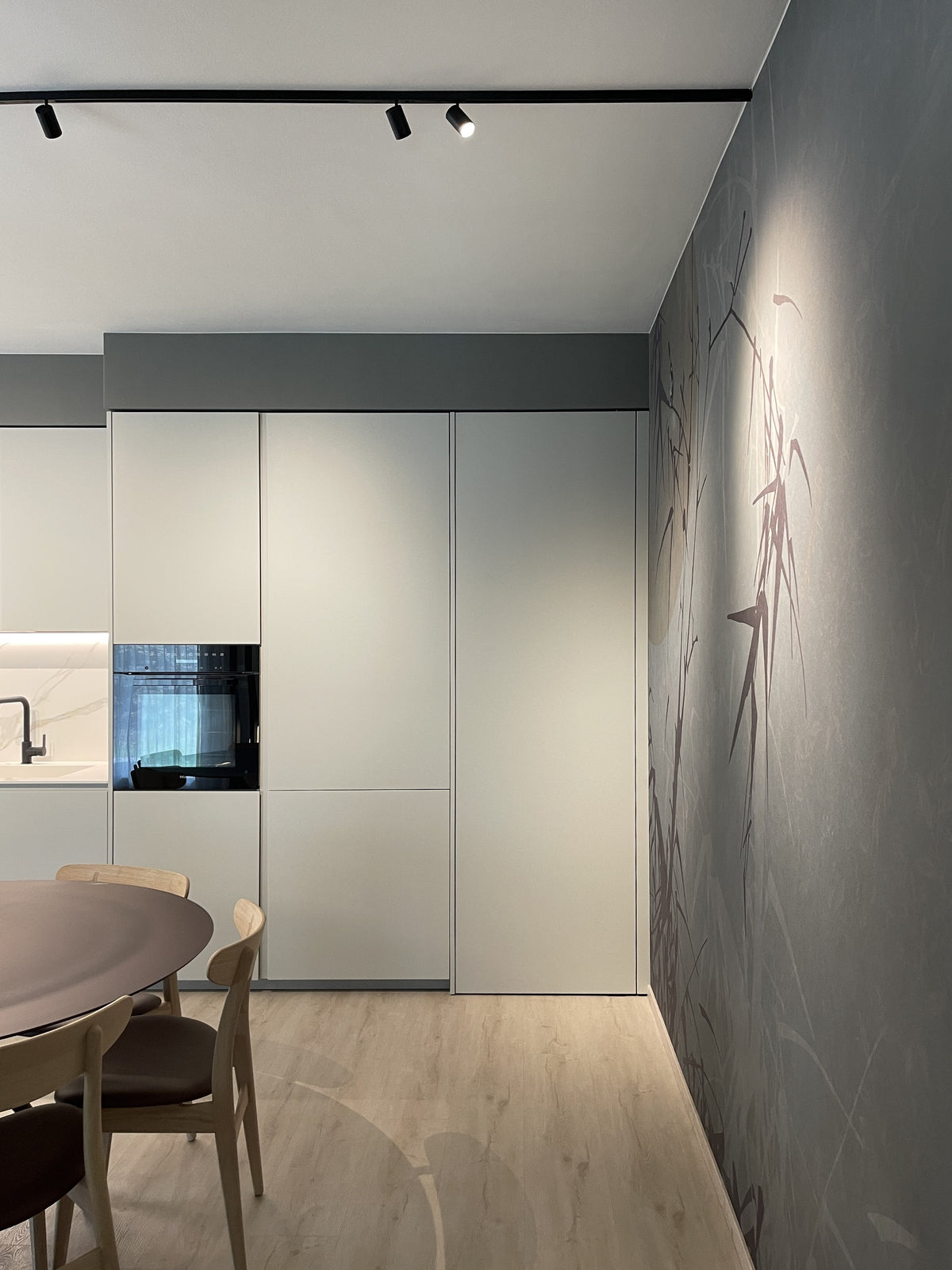Porta pivot chiusa perfettamente integrata nelle ante della cucina e nella parete attrezzata