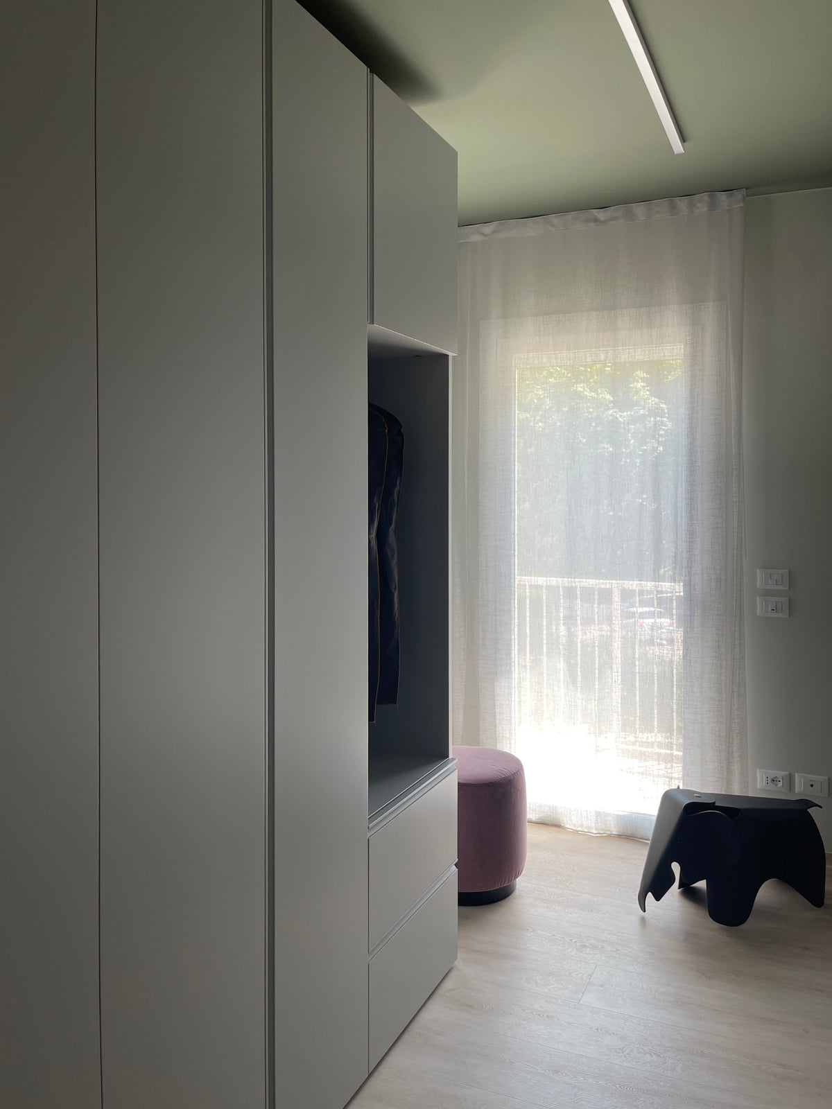 Cabina armadio su misura con armadiature a tutta altezza, nicchia attrezzata e soffitto verde desaturato