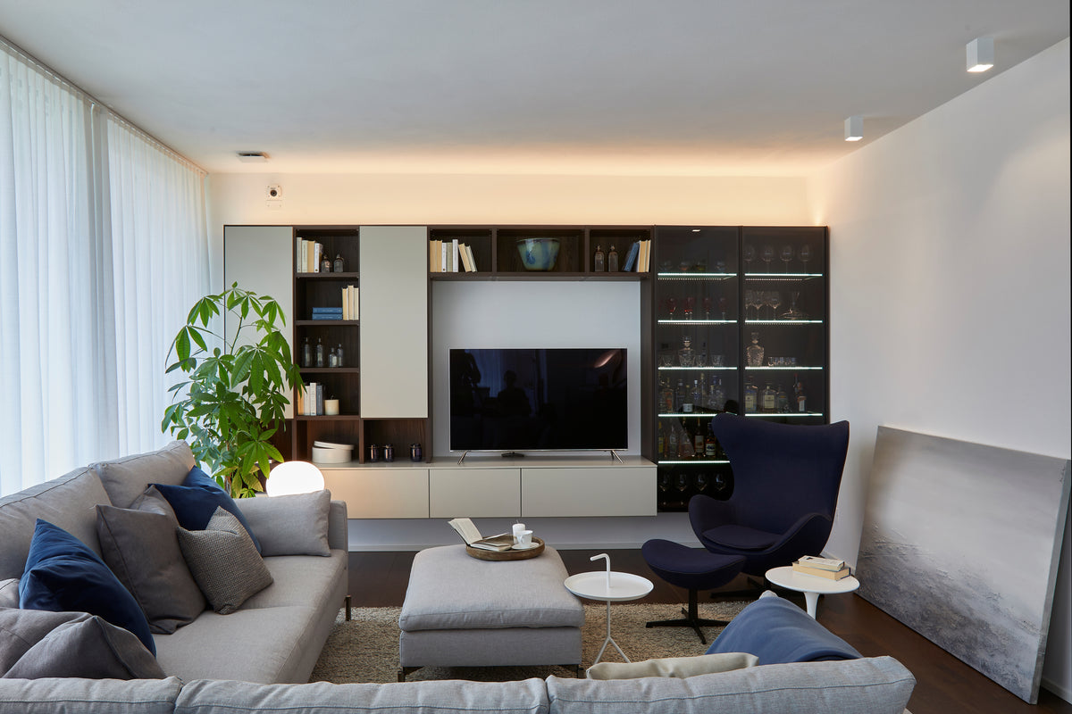 Zona living con divani e arredi integrati in open space luminoso, equilibrio tra funzionalità ed estetica