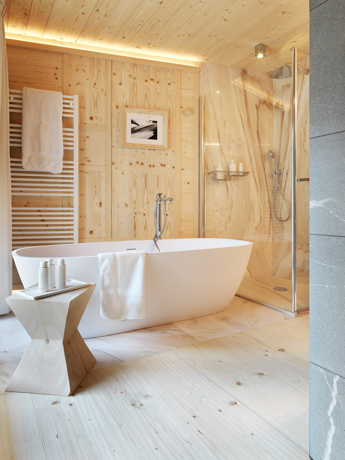Bagno in legno con vasca freestanding e doccia a vista, spazio dedicato al benessere domestico
