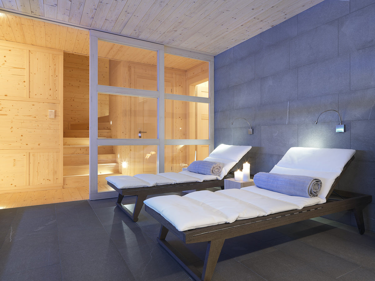 Area relax della spa con lettini e pareti in pietra, ambiente dedicato al relax in casa