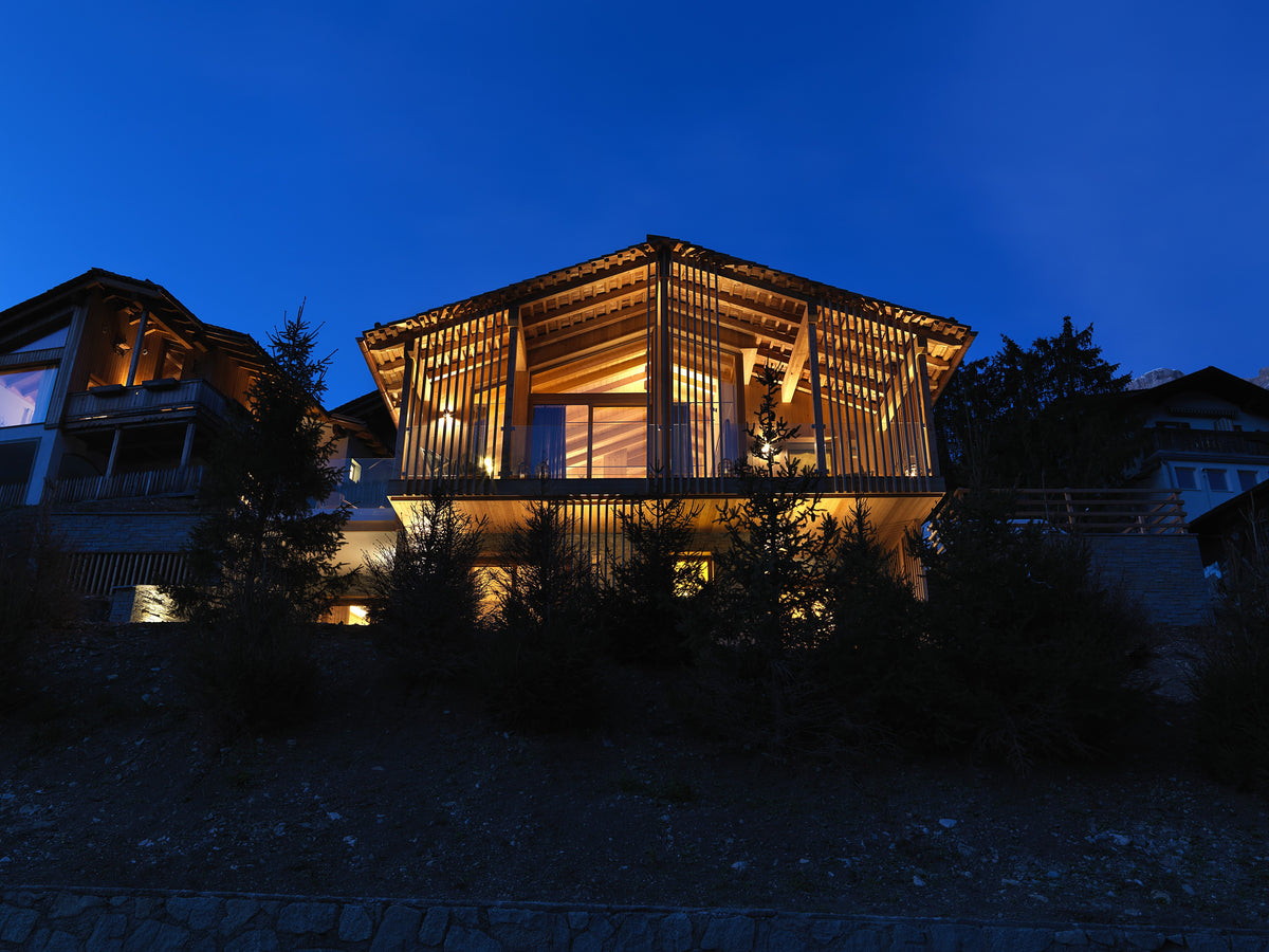 Facciata dello chalet contemporaneo con volumi vetrati e dialogo con l’ambiente montano