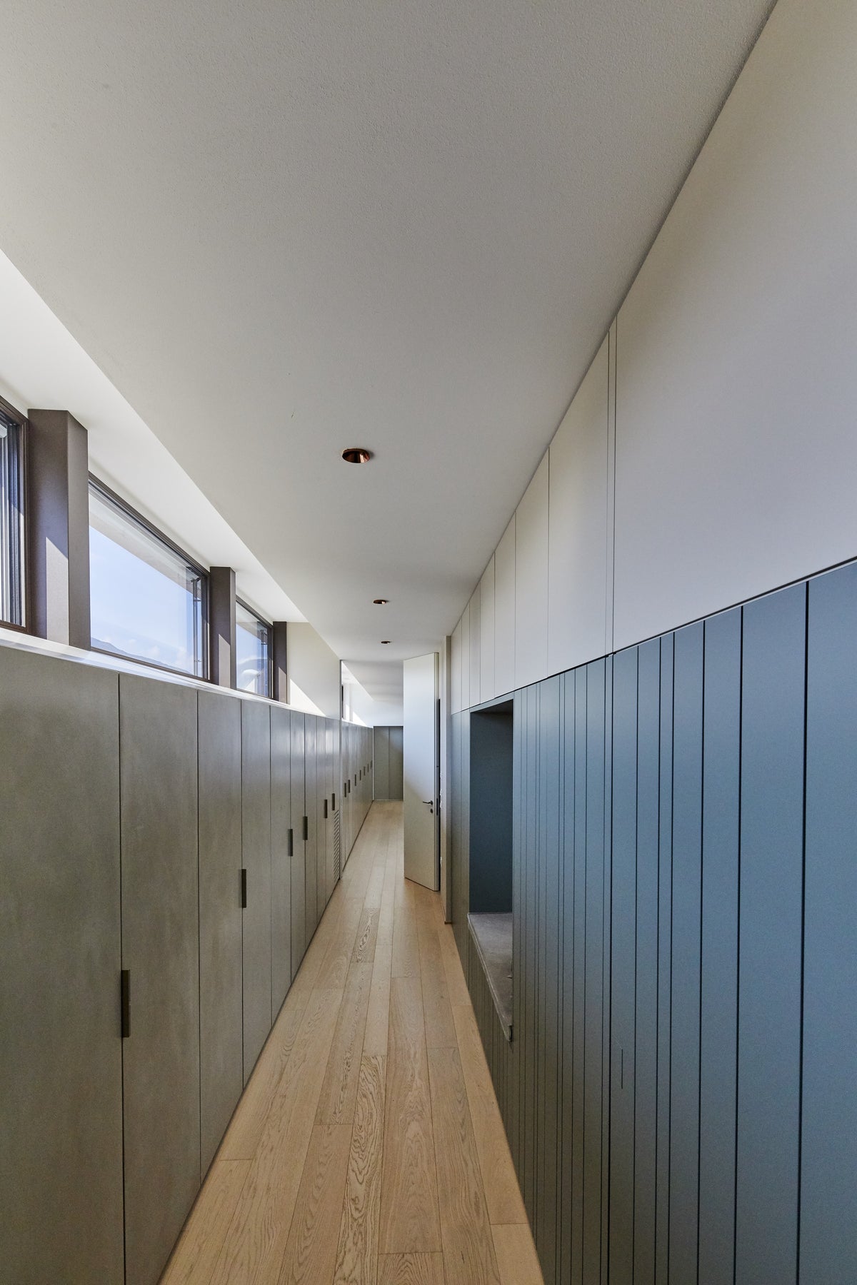 Corridoio notte con armadiature integrate e boiserie blu in progetto su misura