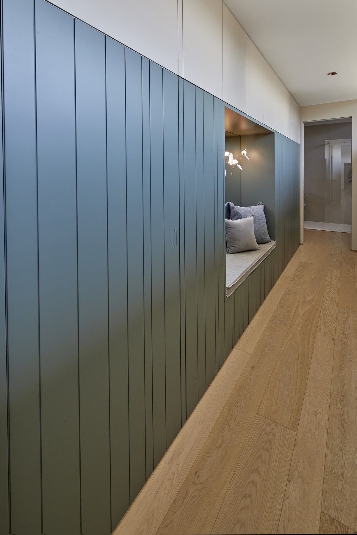 Disimpegno con rivestimento verticale blu e passaggio verso la zona bagno