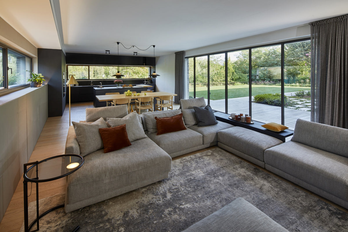 Living con grande divano modulare e aperture sul giardino