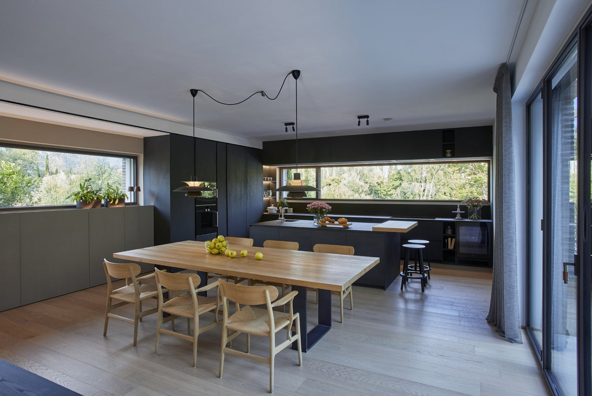 Cucina con isola nera e tavolo in legno, progetto di interior design residenziale su misura