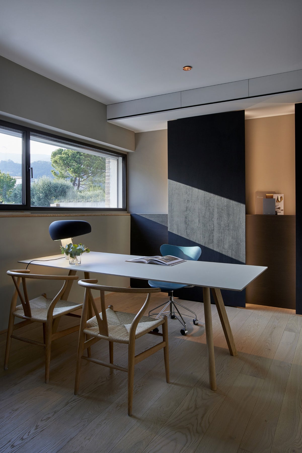 Studio con scrivania, lampada di design e parete attrezzata su misura