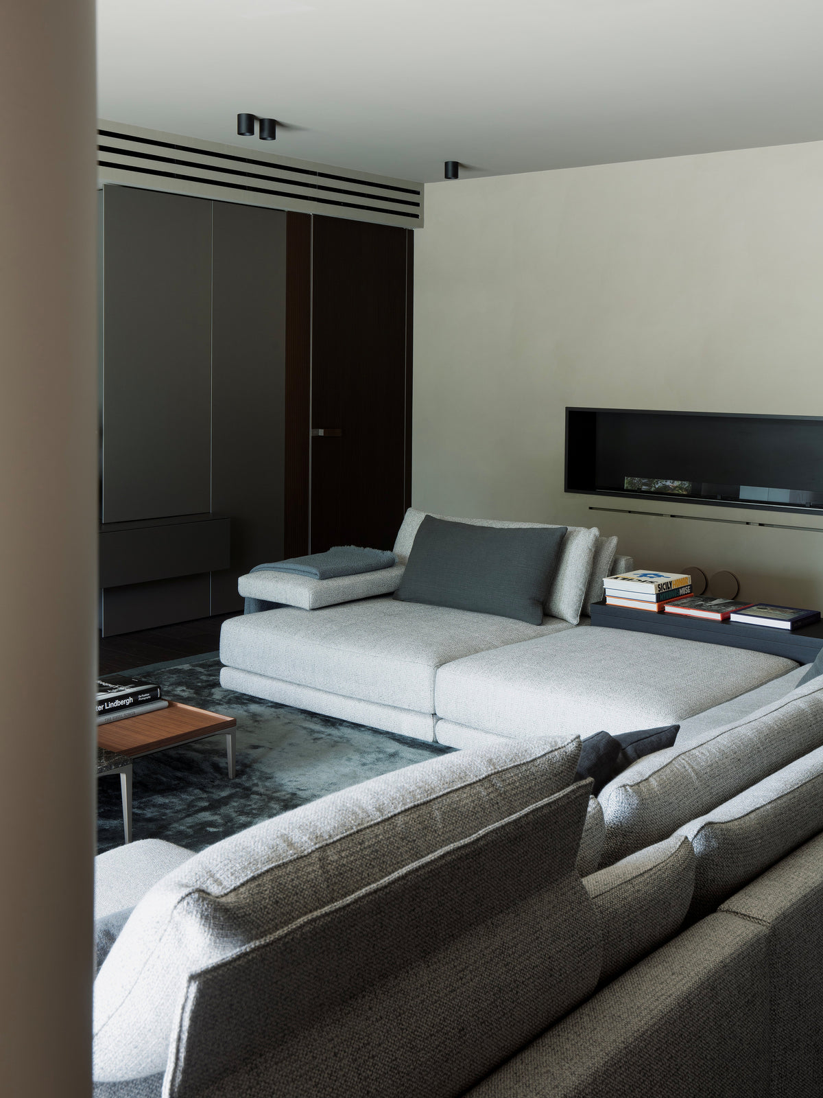 Zona living con divano modulare e parete TV su misura