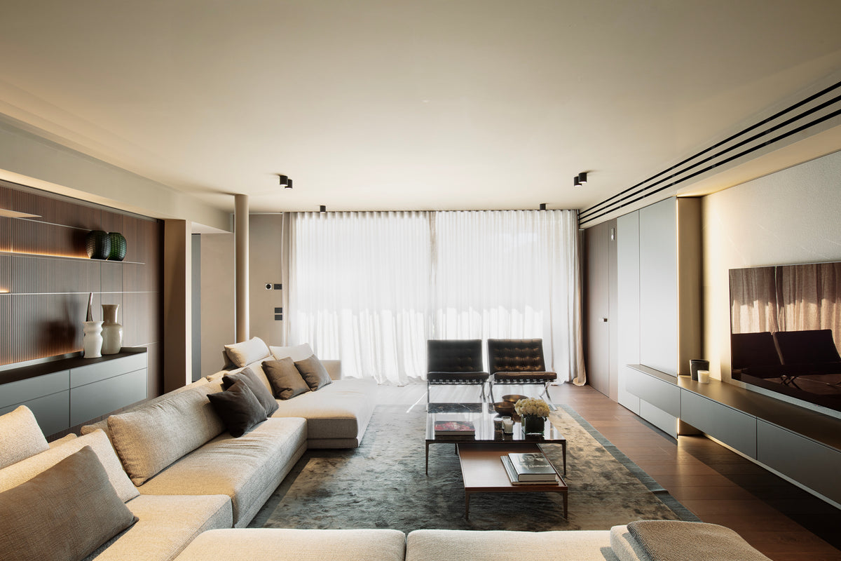 Living elegante con divano componibile Poliform, libreria integrata e tende a tutta altezza