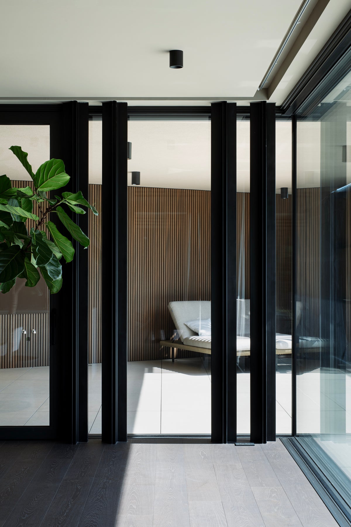 Apertura sul patio esterno con area lounge e rivestimenti in legno
