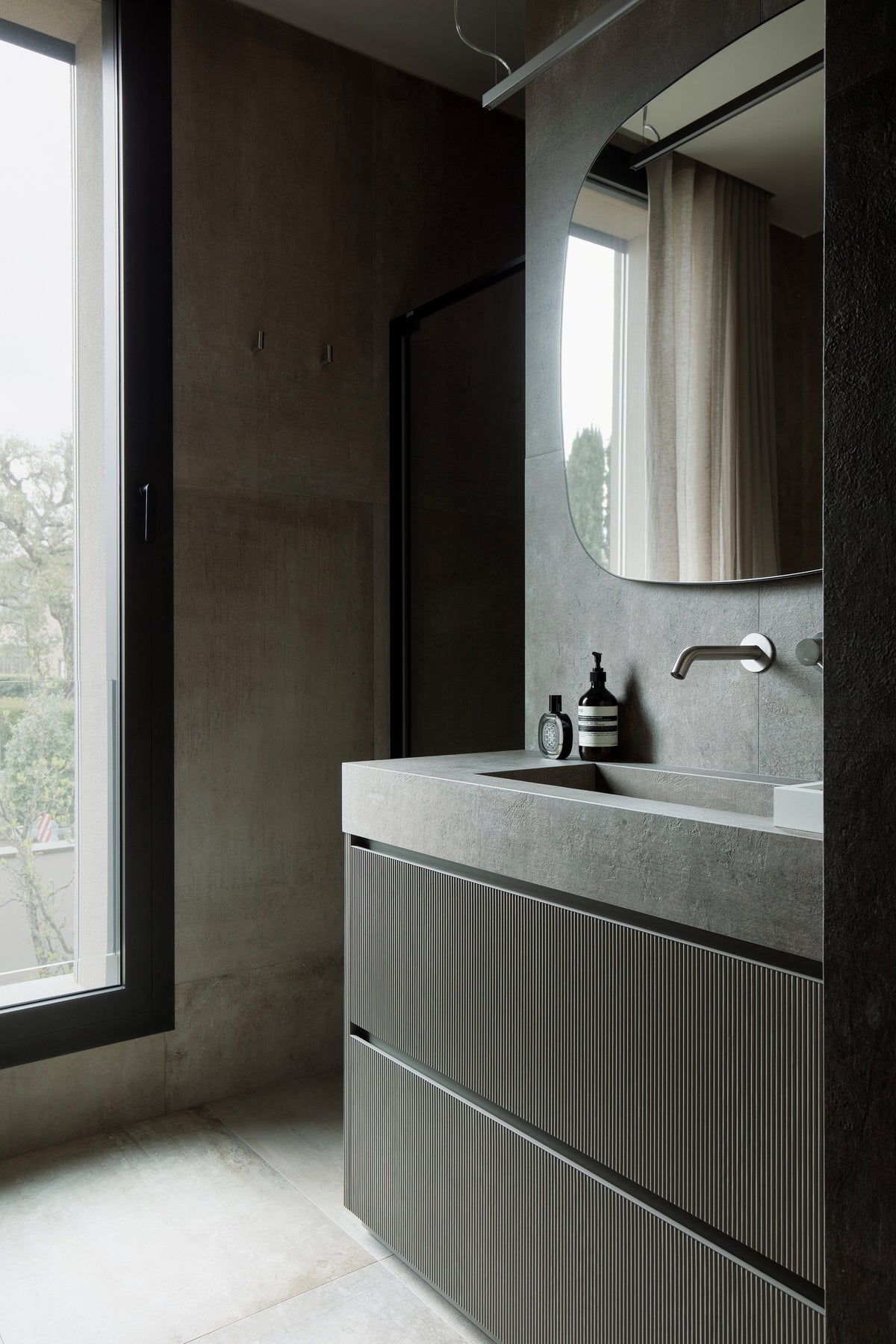 Bagno con mobile lavabo scanalato e grande specchio sagomato