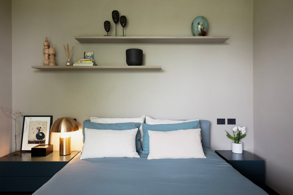 Vista frontale della camera con letto imbottito e styling essenziale