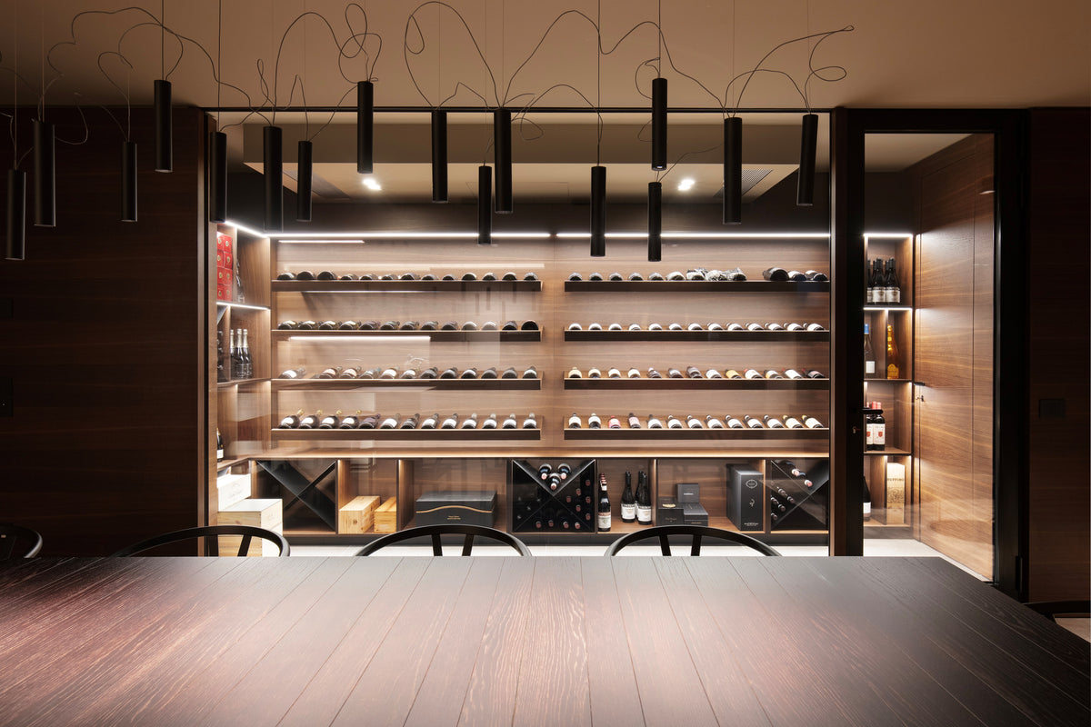 Cantina vini su misura con vetrata e scaffalature illuminate